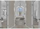 Luxurious bathroom featuring a raised soaking tub, arched windows, and a serene, spa-like atmosphere at 407 Blue Smoke Trl, Peachtree City, GA 30269