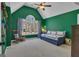 Green bedroom features a ceiling fan, a daybed, a rocking chair, and an arched window with natural light at 407 Blue Smoke Trl, Peachtree City, GA 30269