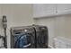 Modern laundry room with front load washer and dryer, white cabinets for storage, and organized space at 407 Blue Smoke Trl, Peachtree City, GA 30269