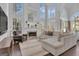 Spacious living room featuring a fireplace, high ceilings, and large windows showcasing the outdoor view at 407 Blue Smoke Trl, Peachtree City, GA 30269