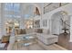 Bright, open living area featuring a large sofa, high ceilings, and natural light streaming in from expansive windows at 407 Blue Smoke Trl, Peachtree City, GA 30269