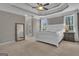 Inviting main bedroom featuring tray ceilings, lots of windows, a ceiling fan, and neutral color scheme at 407 Blue Smoke Trl, Peachtree City, GA 30269