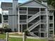 Gray apartment building exterior with white staircases and railings, surrounded by lush greenery at 3480 Shepherds Path, Decatur, GA 30034