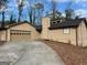 Charming single-story home features attached garage and neutral-toned siding, set in a wooded landscape at 1725 Sara Se Ct, Conyers, GA 30013