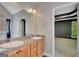 Double sink vanity with stained wood cabinets and a doorway to the main bedroom at 85 Parks Pl, Sharpsburg, GA 30277