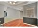 Open-concept dining room with hardwood floors, wainscoting, and a view leading into the living area at 85 Parks Pl, Sharpsburg, GA 30277
