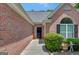 Charming brick home entrance with a black door, complemented by well-maintained landscaping and decorative elements at 85 Parks Pl, Sharpsburg, GA 30277
