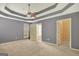 Spacious main bedroom with tray ceiling, carpet and doorways to bathroom and walk-in closet at 85 Parks Pl, Sharpsburg, GA 30277