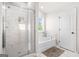 Bright bathroom featuring a glass-enclosed shower and soaking tub with white marble-style tile at 361 Traditions Ln, Hampton, GA 30228