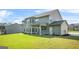 Back of house with covered patio and grassy yard at 361 Traditions Ln, Hampton, GA 30228