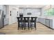 Stylish kitchen boasts white cabinets, stainless steel appliances, a center island, and modern fixtures at 361 Traditions Ln, Hampton, GA 30228