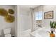 A bright bathroom featuring a tub, double vanity, stylish mirror, and ample light at 318 Sound Circle, Stockbridge, GA 30281