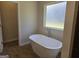 Elegant bathroom featuring a freestanding tub and a window at 1676 Fuma Leaf Way # 305, Mcdonough, GA 30253