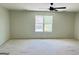 A bedroom featuring ceiling fan and large window, highlighting bright and open space at 8035 Buffet Trl, Riverdale, GA 30296