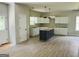 A kitchen featuring recessed lights, a black island, white cabinets, and hardwood flooring at 8035 Buffet Trl, Riverdale, GA 30296