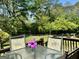 Inviting back deck with glass table and chairs, perfect for enjoying outdoor living and lush green scenery at 107 Woodhaven Dr, Stockbridge, GA 30281
