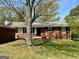 Charming single-story brick home with a well-maintained front yard and mature shade trees at 107 Woodhaven Dr, Stockbridge, GA 30281