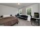 Neutral bedroom featuring a black futon, desk setup, and lots of natural light creating a calm space at 433 Wilson Dr, Mcdonough, GA 30252
