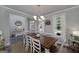 Dining room features a large wooden table, white chairs, and ample natural light from surrounding windows at 433 Wilson Dr, Mcdonough, GA 30252