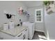 Well-organized laundry room features granite countertops, white cabinets and shelving for storage at 433 Wilson Dr, Mcdonough, GA 30252