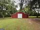 Spacious red barn with a large garage door, providing ample storage and potential for various uses at 435 Jackson St, Locust Grove, GA 30248