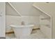 Bathroom features a freestanding tub, tiled floors, and natural light from an octagonal window at 435 Jackson St, Locust Grove, GA 30248