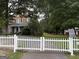 Charming home with a white picket fence, surrounded by mature trees and a well-manicured lawn at 435 Jackson St, Locust Grove, GA 30248