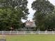 Classic home framed by mature trees and a white picket fence, offering timeless charm and curb appeal at 435 Jackson St, Locust Grove, GA 30248