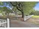Traditional home with a circular driveway, mature tree and white picket fence, surrounded by mature trees and lush greenery at 435 Jackson St, Locust Grove, GA 30248