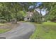 Traditional home with a circular driveway and ample yard space, surrounded by mature trees and lush greenery at 435 Jackson St, Locust Grove, GA 30248
