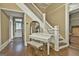 Warm foyer with elegant staircase and hardwood floors, accented by a stylish piano and a decorative mirror at 435 Jackson St, Locust Grove, GA 30248