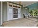 Spacious front porch featuring classic wicker furniture and an inviting space for relaxation, white columns, brick steps at 435 Jackson St, Locust Grove, GA 30248
