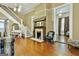 Elegant living room with hardwood floors, fireplace, piano, and staircase in a light, neutral color scheme at 435 Jackson St, Locust Grove, GA 30248