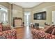 Living room featuring hardwood floors, a fireplace, and neutral walls with a television at 435 Jackson St, Locust Grove, GA 30248
