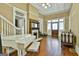 Bright living room featuring a piano, fireplace, staircase, and hardwood floors, illuminated by natural light at 435 Jackson St, Locust Grove, GA 30248