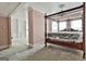Bright bedroom featuring a four-poster bed frame, chandelier, and view to a fireplace in the sitting room at 435 Jackson St, Locust Grove, GA 30248