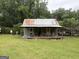 Quaint outbuilding with a covered porch, set in a lush green lawn, offering rustic charm and functionality at 435 Jackson St, Locust Grove, GA 30248