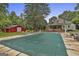 Beautiful pool area with a green cover, surrounded by trees, statues, and lounge chairs, with the house in the background at 435 Jackson St, Locust Grove, GA 30248