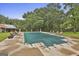 Large pool area with covered pool, surrounded by mature trees, a small cottage and statuary at 435 Jackson St, Locust Grove, GA 30248