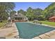 Spacious pool area with covered pool, surrounded by greenery and a charming home with a large porch at 435 Jackson St, Locust Grove, GA 30248
