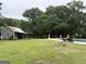 Expansive yard featuring a pool, charming outbuilding, and lush greenery, perfect for outdoor activities at 435 Jackson St, Locust Grove, GA 30248