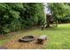 Backyard featuring fire pit, seating, and a quaint tree house amidst mature trees at 639 Sheffield Ct, Villa Rica, GA 30180