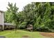 Spacious backyard with a playhouse, a deck and lush greenery and mature trees at 639 Sheffield Ct, Villa Rica, GA 30180