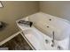 Clean white soaking tub in a bathroom with wood-look floors and modern fixtures at 639 Sheffield Ct, Villa Rica, GA 30180