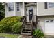 Inviting home entrance featuring a dark front door with decorative wreath and a wooden staircase at 639 Sheffield Ct, Villa Rica, GA 30180