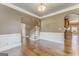 Formal dining room boasting wainscoting, hardwood floors, elegant lighting, and adjacent staircase at 100 Harmony Ct, Dallas, GA 30157
