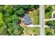 Aerial view of a home with a neatly maintained lawn and driveway, surrounded by beautiful, mature trees at 1621 White Oak Cv, Loganville, GA 30052