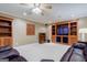 Entertainment area with large TV, built-in shelving, comfortable seating, and a ceiling fan at 1621 White Oak Cv, Loganville, GA 30052