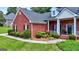 Beautiful red brick home with manicured landscaping, and an inviting front porch at 1621 White Oak Cv, Loganville, GA 30052