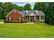 Charming red brick home featuring a well-manicured lawn and inviting front porch at 1621 White Oak Cv, Loganville, GA 30052